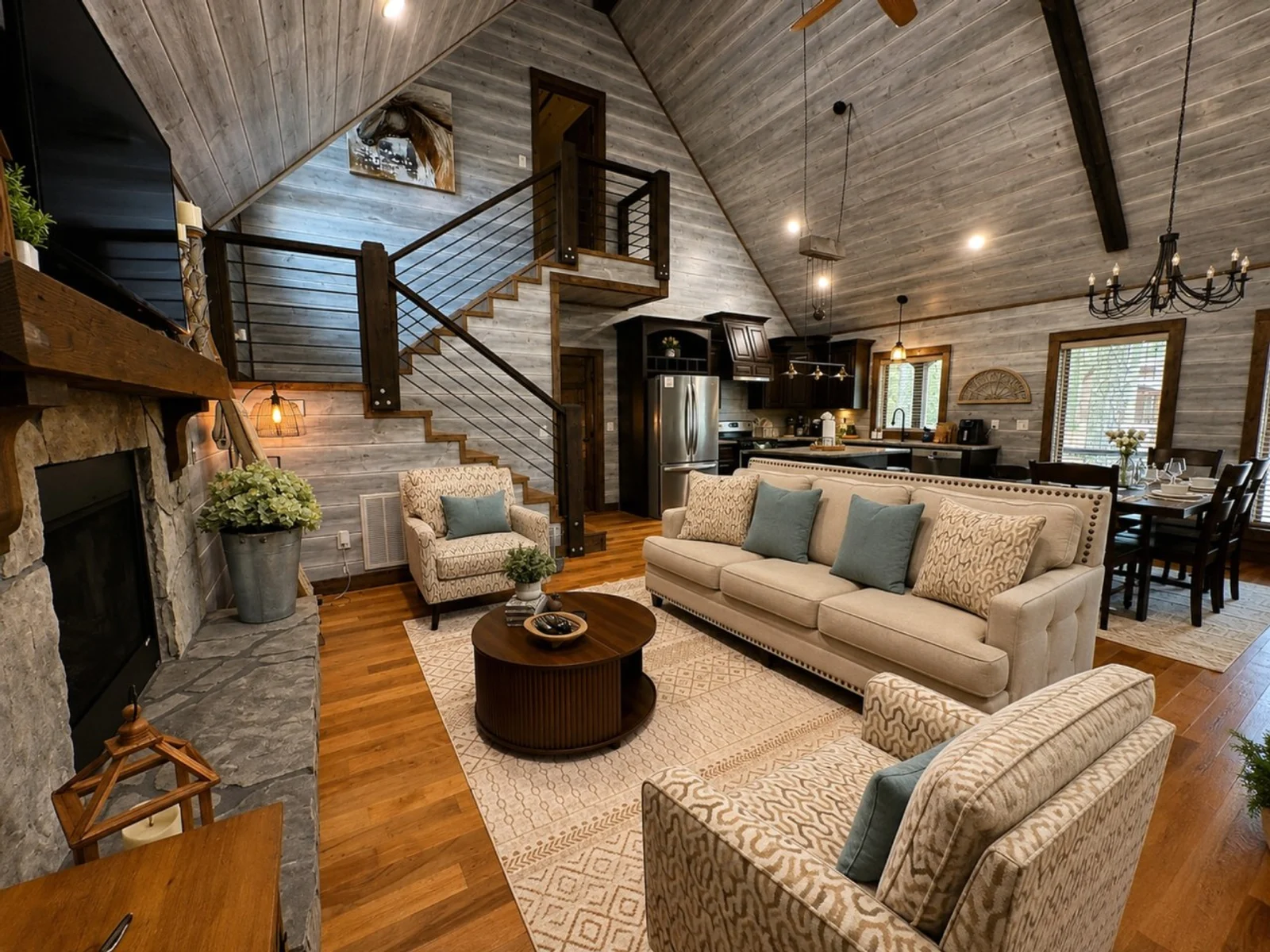 Vaulted living room with fireplace, comfortable seating and an open kitchen