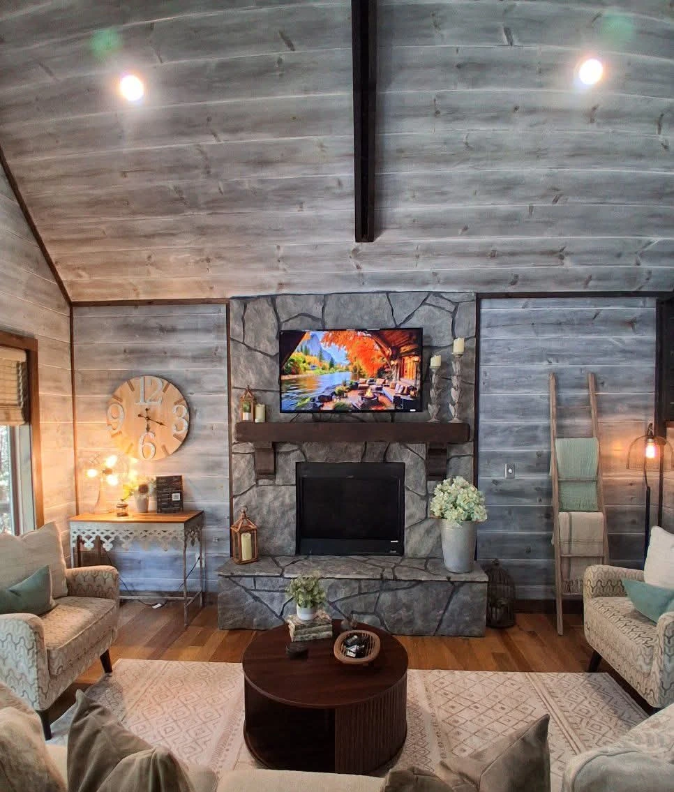 Living room and stone fireplace at The Rustic Reserve